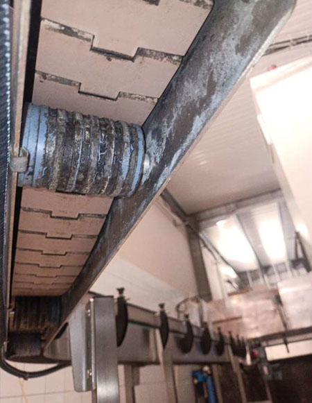 Usure de la chaîne du convoyeur avant maintenance Détail de la chaîne et du système de guidage d’un convoyeur industriel avant maintenance