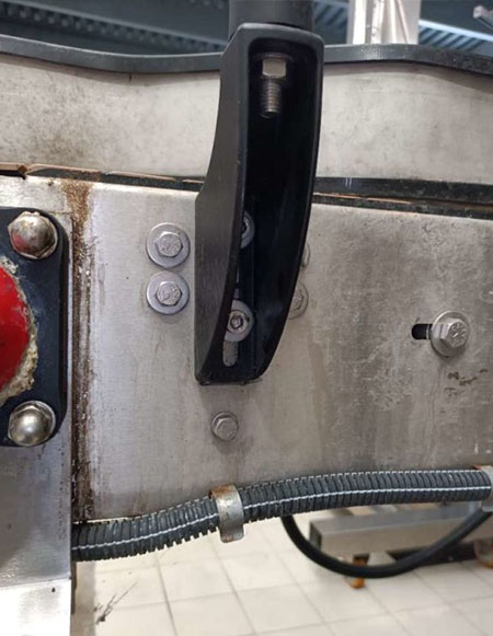 Contrôle d’un réglage mécanique du convoyeur industriel Détail d’un dispositif de réglage mécanique sur un convoyeur industriel avant maintenance