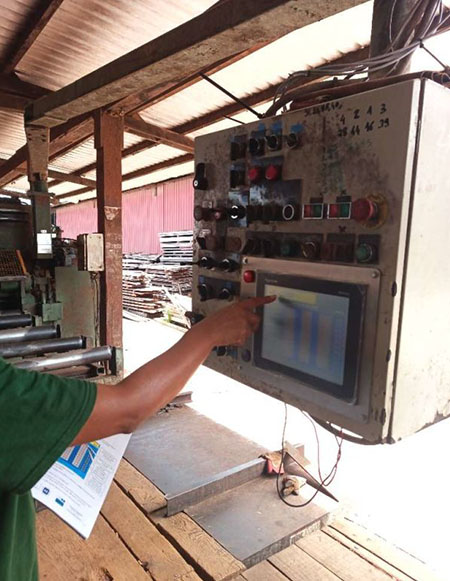 Mise en service du pupitre de commande modernisé Technicien testant l’écran de commande d’une machine industrielle après modernisation